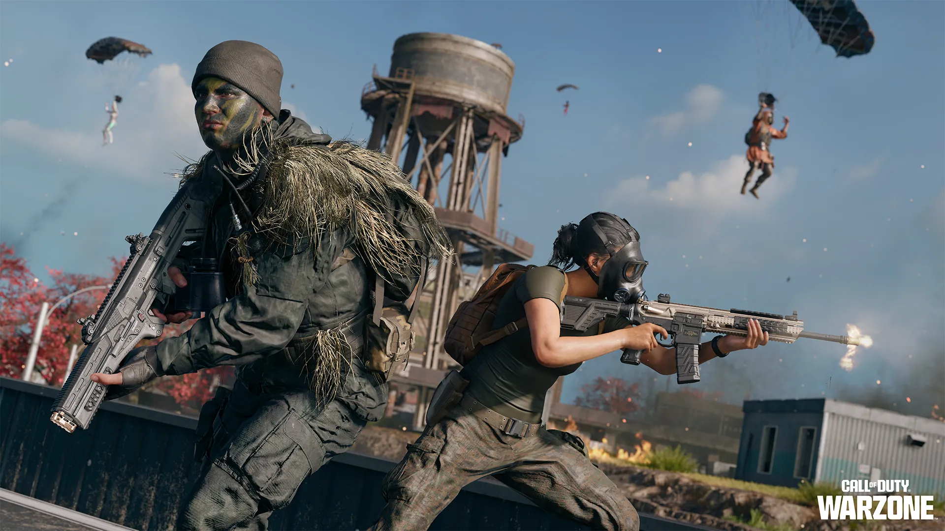 Two armed operators fight beneath descending parachutists near a tall water tower.