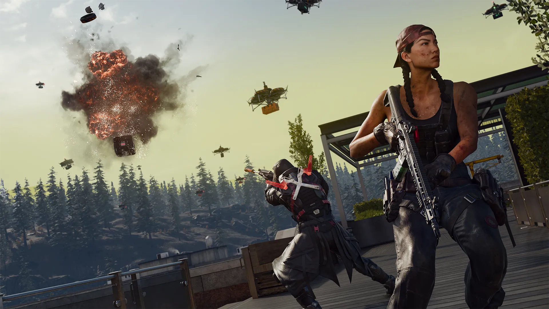 Operators take cover beneath exploding supply drones while one scans the battlefield with a rifle.