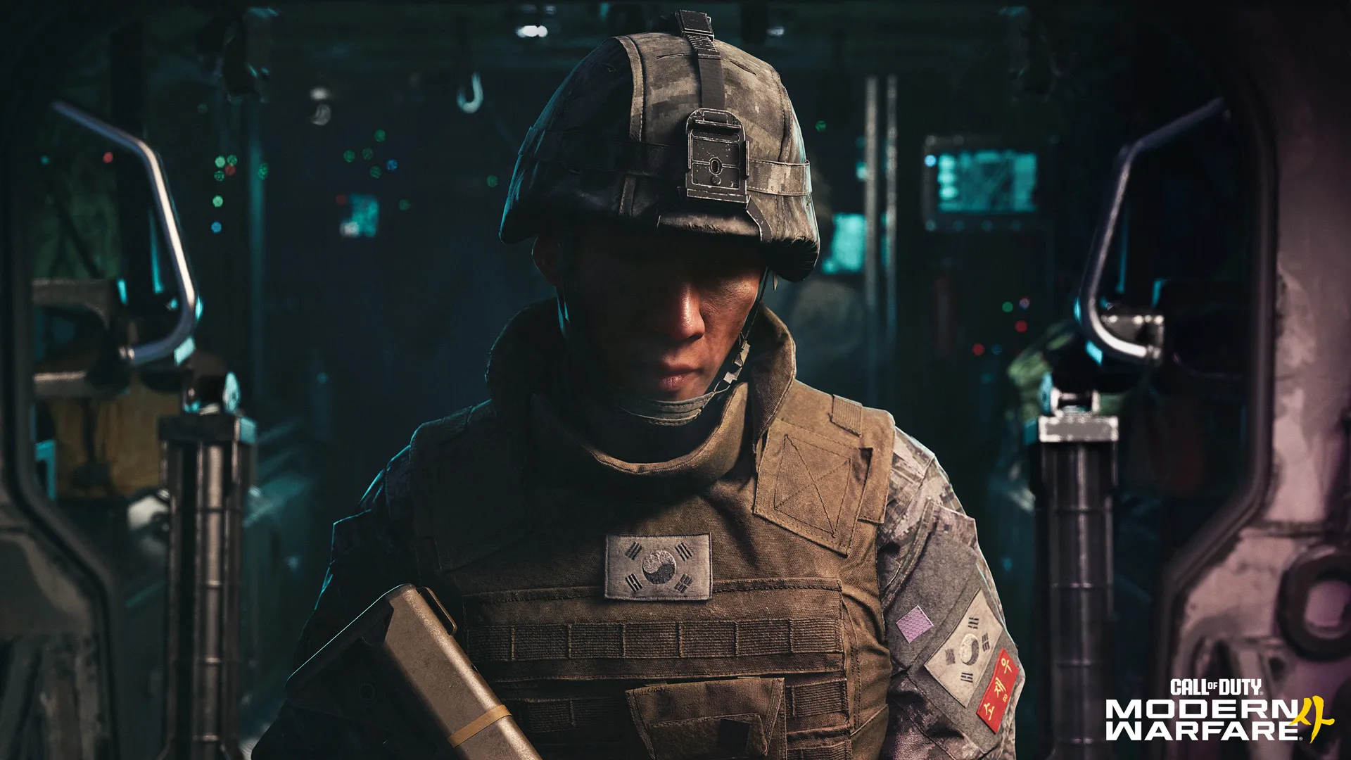 A South Korean soldier wearing a helmet and tactical vest stands inside a dimly lit military vehicle.