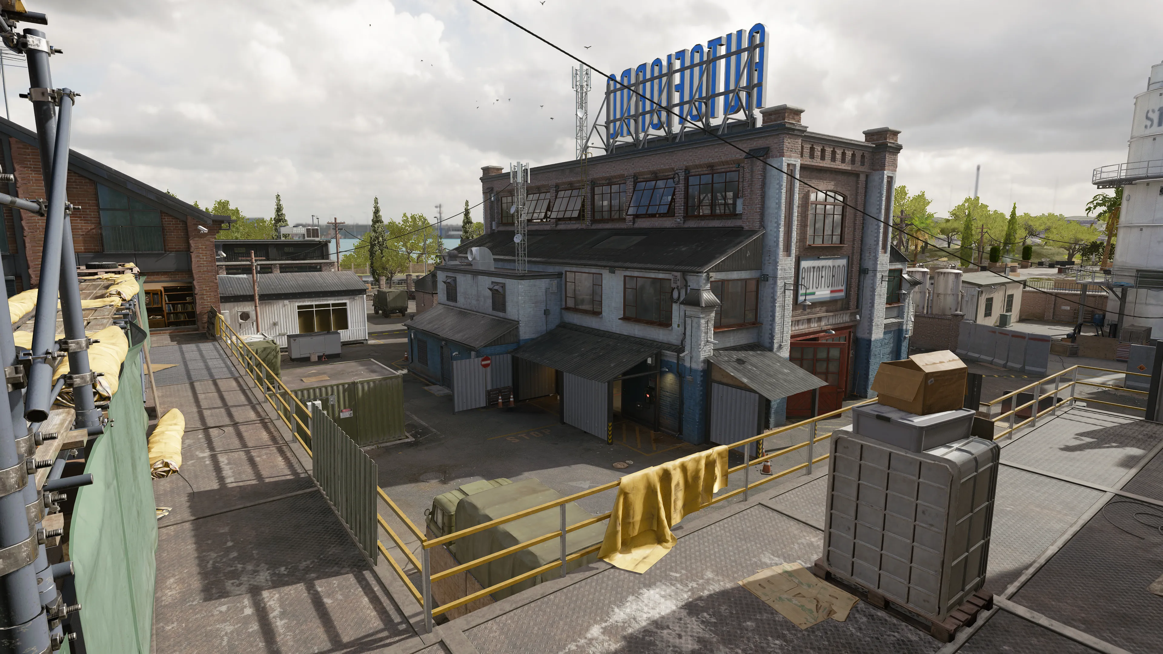From inside an office, the window view reveals a courtyard with containers, a white car on a raised platform, and a brick factory in the distance. Trophies and framed documents decorate the room. (Description by ChatGPT)