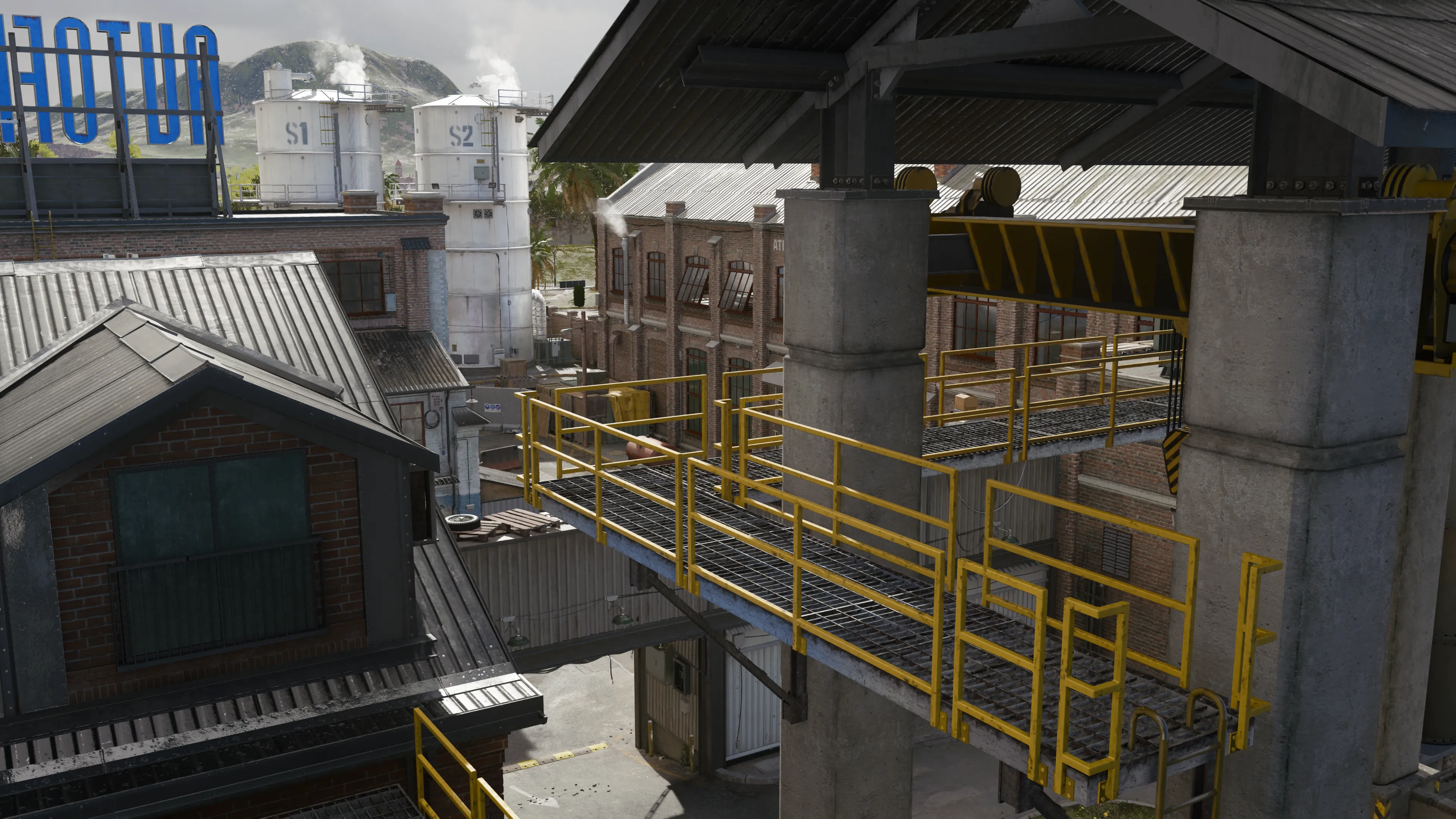 A rooftop and catwalk view overlooks a loading dock and a brick building labeled "Autofiorno." The area appears deserted and industrial. (Description by ChatGPT)